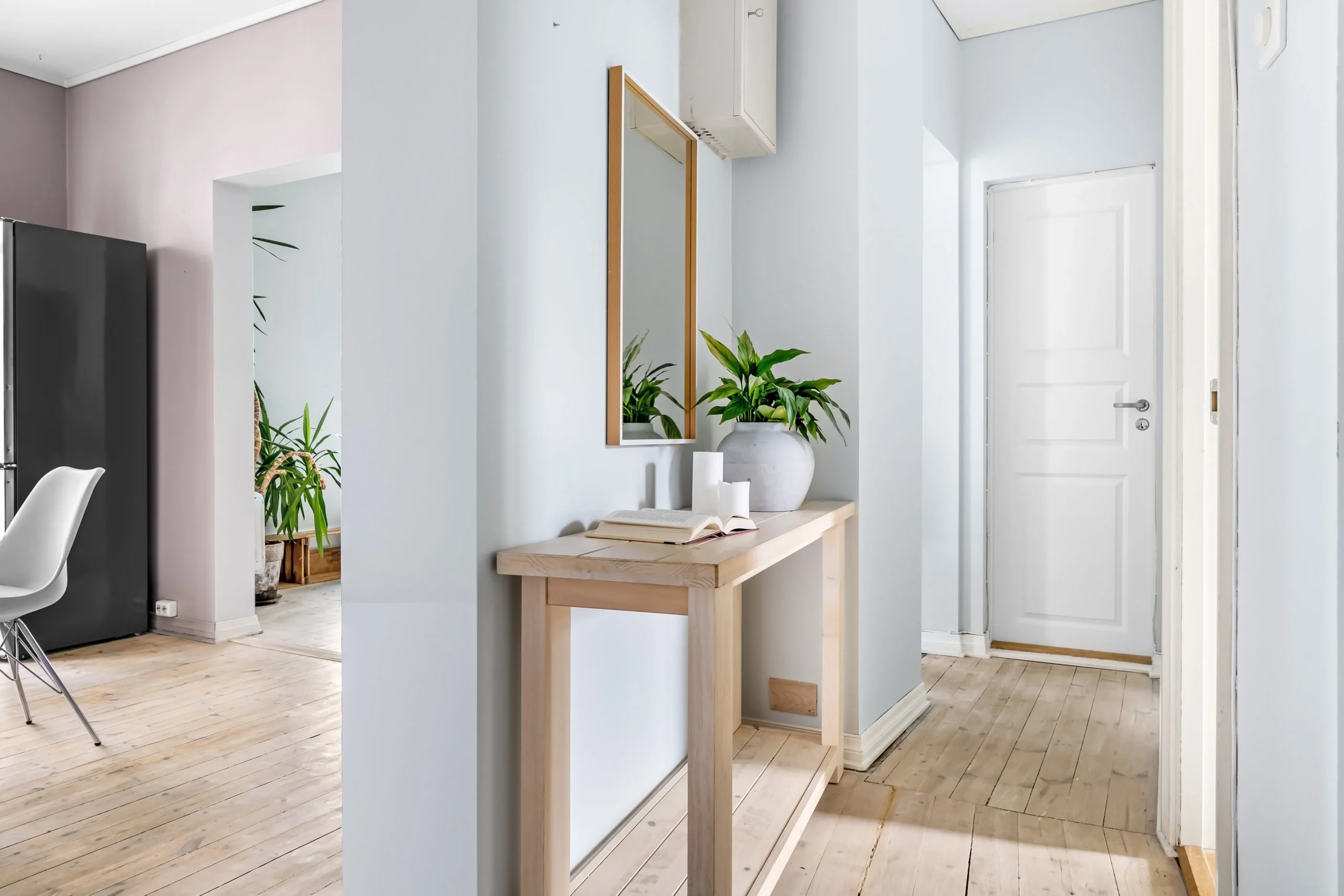 Couloir d'entrée décoré de plantes vertes et de cadres botaniques